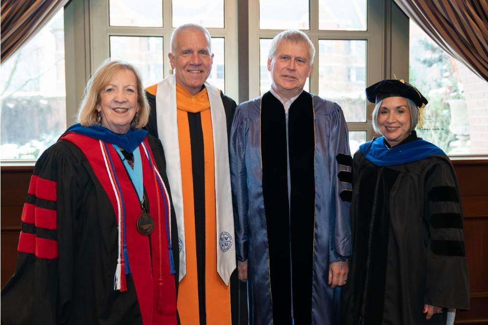4 faculty smiling for a photo before convocation